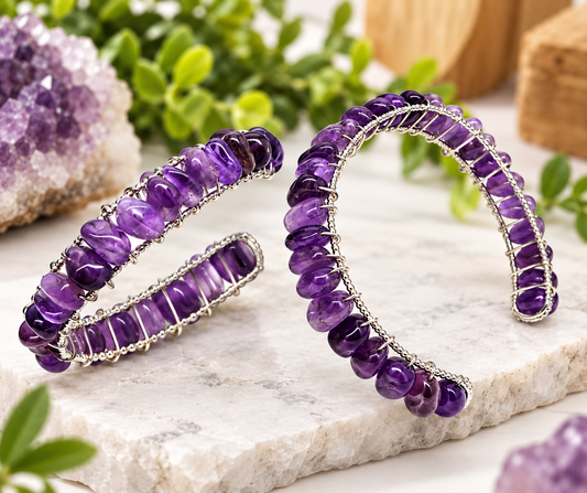 Purple amethyst wire-wrapped gold overlay cuff bracelet worn on wrist, showing natural gemstone detail and flexible bangle design.