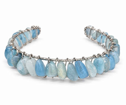 Close-up of natural aquamarine gemstones secured with intricate gold wire wrapping