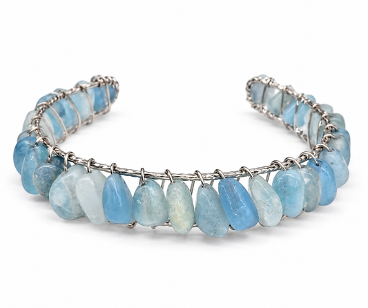 Close-up of natural aquamarine gemstones secured with intricate gold wire wrapping